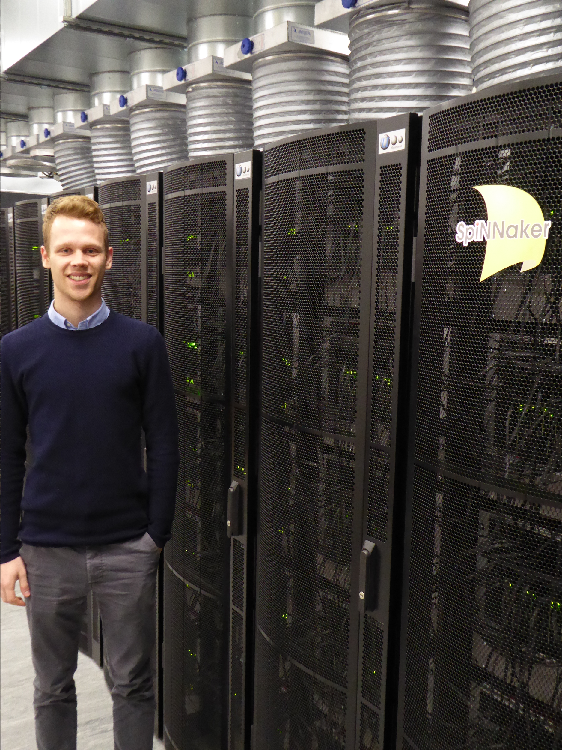 Me on the day of my presentation next to the “big” SpiNNaker machine with 1 million cores.